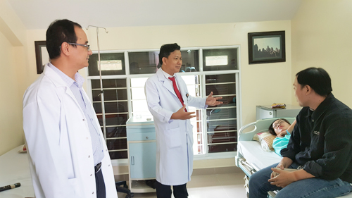 ThS. BS Lê Thanh Quang (trái) thăm hỏi bệnh nhân sau phẫu thuật